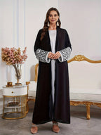 A Loose Black And White Embroidered Muslim Dress in a Single Piece - a Dubai-Style Elegant And Conservative Outerwear with Tassels And a Belt Suitable for All Seasons - Black