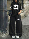 A Two-Piece Set for Women Featuring a Printed Round-Neck Short-Sleeve Top And Loose Drawstring Pants, Perfect for Trendy Summer Streetwear - Black