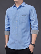 Men's Oxford Cloth Long-Sleeve Shirt for Spring/Autumn, with Lapel Collar, Simple Pocket, and English Print Decoration. Features Contrast Color Cuffs and Collar Design. A Versatile Basic Shirt for Business Casual Wear, Available in Multiple Colors - Light Blue