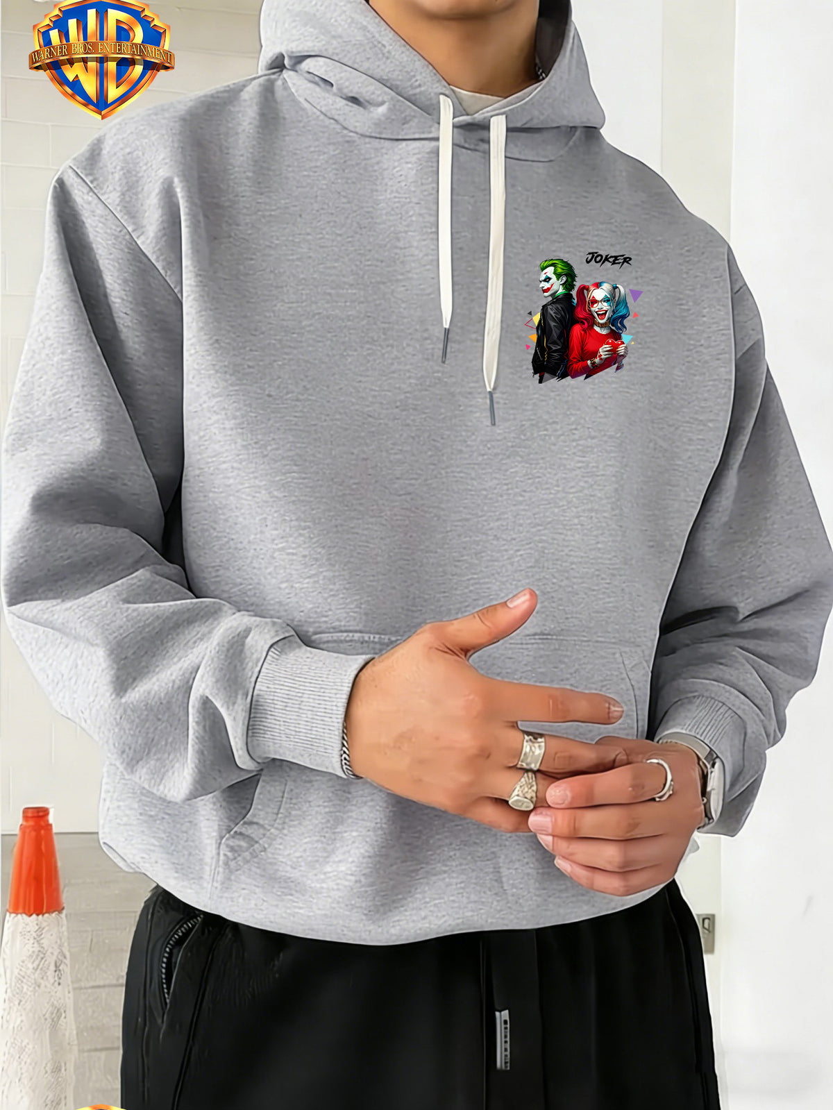 Warner Bros. American Comic-style Joker and Harley Quinn Back-to-back Design, JOKER Title Character with Heart Graphic and Colorful Triangle Accents, Trendy and Cool Printed Men's Fashion Hooded Sweatshirt, Sleeve Print Design, Kangaroo Pocket - Light Grey