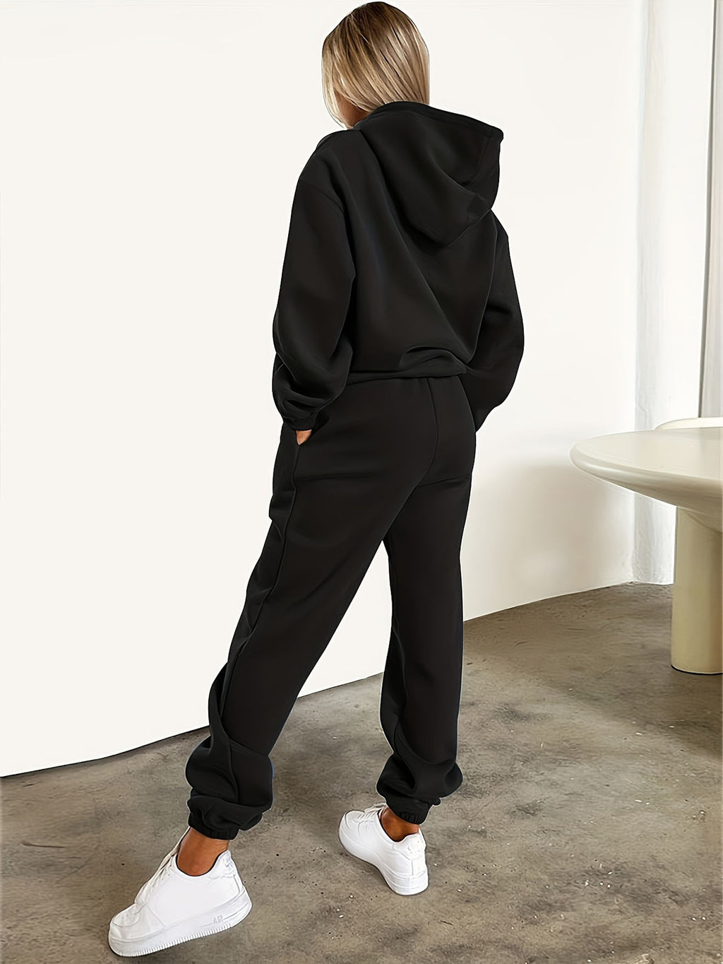 Autumn/Winter Trendy Fashion Women's Hooded Drawstring Sweatshirt and Sweatpants Set. Features a Hooded Drawstring Design and a Front Kangaroo Pocket on the Sweatshirt for Comfortable Cold-weather Wear. Classic Silhouette with a Comfortable Fit. - Black