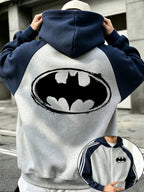 Officially Licensed by Warner Bros., This New Men's Colour-blocked Fashion Hoodie Features a Batman Logo Print with a Brushstroke Border. A Zipped Hooded Jacket for Autumn and Winter, It Has a Relaxed Fit and Is Made from Comfortable Fabric. - Grey-blue