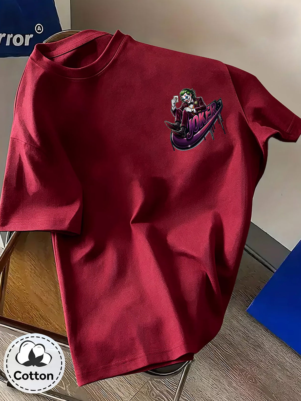 Warner Bros. Official Unisex Summer Loose-Fit Crew Neck Short-Sleeve T-Shirt, Suitable for Daily Commutes, Street Outings, City Trips, and Friend Gatherings. Features a Large Burgundy Suit-wearing Joker Sitting on Purple Graffiti Sneakers - Burgundy