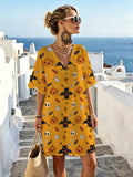 Warm Yellow Halloween Cartoon-themed V-neck Casual Dress, Featuring a Playful and Whimsical Print Combining Pumpkins, Candies, Bats, and Ghosts. The Loose-fit Design with Dropped Shoulders and Short Sleeves Offers Great Figure-flattering Versatility. - Mixed colors