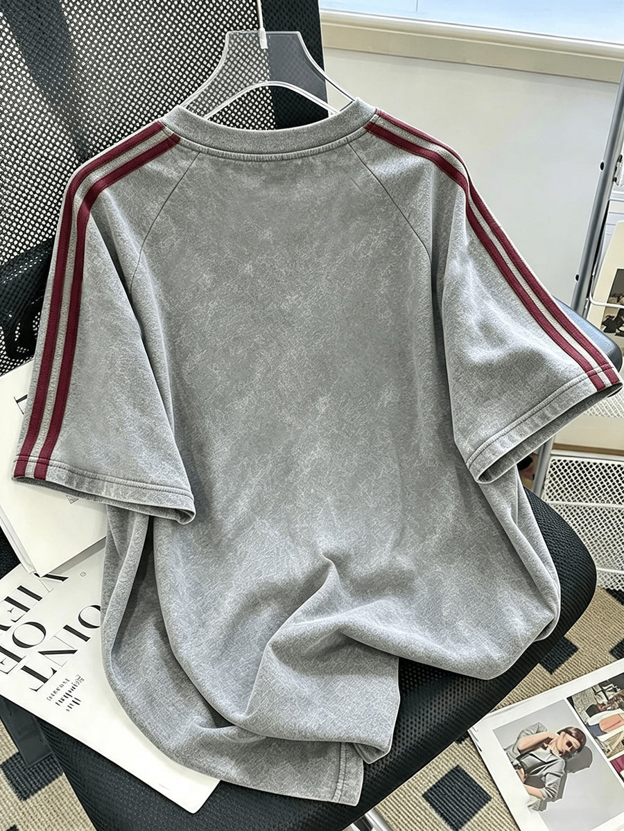Officially Licensed by Warner Bros. - T-Shirt with a Fun Cartoon Graphic of a Character Wearing Headphones And Sleeves, Featuring a Distressed, Washed-Out Stripe Pattern; Suitable for Outdoor Wear And Sports Activities; Unisex Design - Light Grey